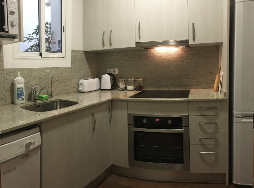 Modern kitchen with induction hob, oven, microwave, dishwasher, fridge/freezer and filtered water.